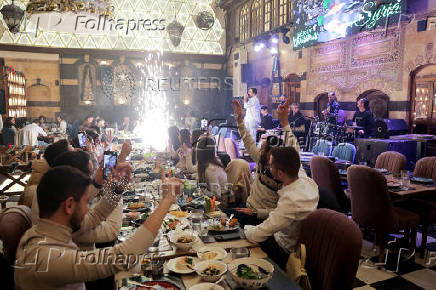 People gather on Christmas day at a restaurant in Damascus