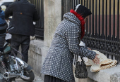 A woman arranges bread along a street in Aleppo