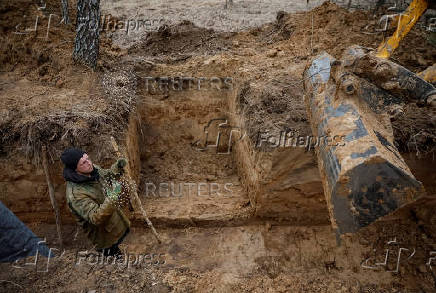 A worker builds a trench as part of a system of new fortification lines near the Russian border in Chernihiv region