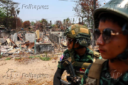 Soldiers from the Karen National Liberation Army (KNLA) patrol , next to an area destroyed by Myanmar's airstrike in Myawaddy, the Thailand-Myanmar border town under the control of a coalition of rebel forces led by the Karen National Union