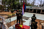 FILE PHOTO: LT Saw Kaw, a soldier of the Karen National Liberation Army (KNLA) in charge of the Cobra column, raises Karen's national flag after burning Myanmar's national flag at a Myanmar military base on the outskirts of Myawaddy