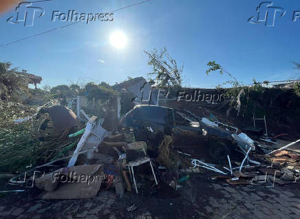 Moradores de Roca Sales (RS), no Vale do Taquari, caminham entre postes cados, casas e carros destrudos