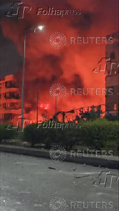 Smoke and flames rise near the hotel Beirut Golden Plaza in Beirut