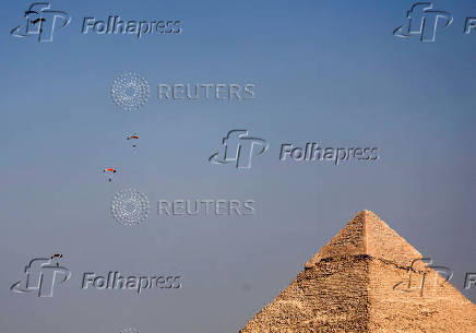 Professional skydivers fly over the historical site of Giza Pyramids, during Egypt International Skydiving Festival 