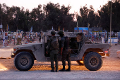 Israeli soldiers stand at the site of the Nova festival where party goers were killed and kidnapped during the October 7 attack by Hamas gunmen from Gaza