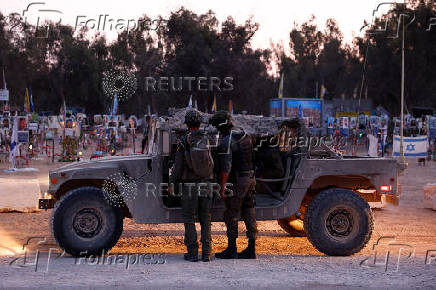 Israeli soldiers stand at the site of the Nova festival where party goers were killed and kidnapped during the October 7 attack by Hamas gunmen from Gaza