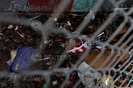 A tattered U.S. flag lies with used syringes and other drug paraphernalia in Bronx, New York City