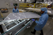 Workers assemble Photovoltaic Modules at the plant of  Adani Green Energy Ltd (AGEL) in Mundra