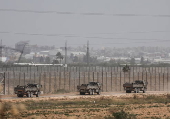 Israeli soldiers maneuver at the border with the Gaza Strip