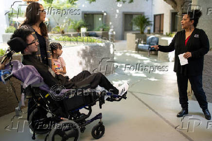 First-time voter Yeshua Loya with his sister Hadassah and mom Mariana Sanchez speak with Monica Murray, Supervisor for the Special Election Board, in Scottsdale