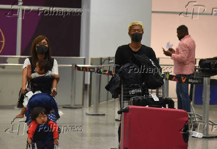 Turistas e funcionrios do Aeroporto do Galeo usam mscaras