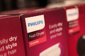 Philips hair dryer boxes are displayed on a shelf in a supermarket