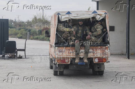 Rebel fighters sit on a vehicle in Homs countryside