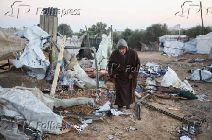 Palestinians inspect the damage at a tent camp sheltering displaced people, in Khan Younis