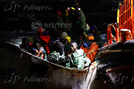 A Spanish Coast Guard vessel tows a fibreglass boat with migrants onboard to the port of Arguineguin, on the island of Gran Canaria