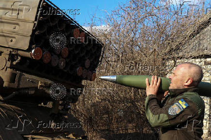 Ukrainian serviceman loads a rocket into a Grad MLRS before firing towards the Russian troops near a front line in the Donetsk region
