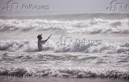 A man takes part in a baptism in the ocean on Good Friday in Durban