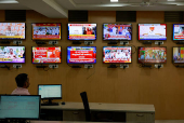 An official looks at television screens inside the media monitoring room ahead of India's general election, at the Office of the Chief Electoral Officer, Bengaluru