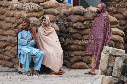 Labourers cover themselves with shawls, in Karachi