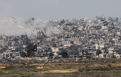 Smoke rises amidst buildings lying in ruin in the Gaza Strip, amid the ongoing conflict between Israel and Hamas, as seen from southern Israel