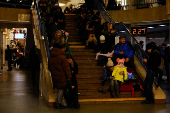 People take shelter inside a metro station during a Russian military strike, in Kyiv