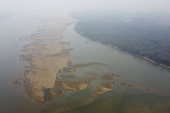 Em meio a fumaa das queimadas sobre imenso banco de areia formado devido a grande seca que atinge o Rio Branco