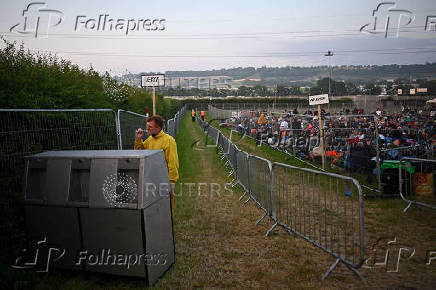 A reveller brushes his teeth as people queue at Worthy Farm for the Glastonbury Festival in Pilton