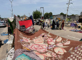 People take refuge along an expressway after relief camps reached maximum capacity in Maiduguri