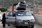 A woman who had fled the hostilities in Lebanon to Syria enters a vehicle as people return to Lebanon through the Masnaa border crossing between the two countries