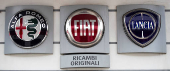 Logos of Alfa Romeo, Fiat and Lancia are displayed outside a car dealership