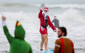 Surfing Santas take to the waves at the annual Christmas Eve event in Cocoa Beach