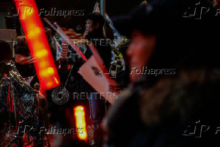 Pro-Yoon protesters are seen in the early light after rallying throughout the night in support of impeached South Korean President Yoon Suk Yeol near his official residence, in Seoul