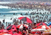 Praia de Copacabana lotada com banhistas e turistas