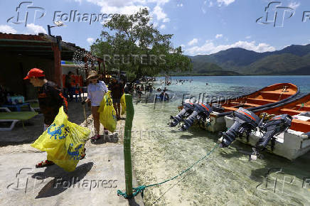 Activists and volunteers collect garbage during the cleanup operation as part of World Beach Day activities, in La Cienega