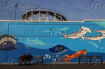 Women sit on the boardwalk of at Coney Island  in the Brooklyn borough of New York City