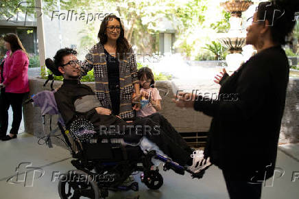 First-time voter Yeshua Loya with his sister Hadassah and mom Mariana Sanchez speak with Monica Murray, Supervisor for the Special Election Board, in Scottsdale