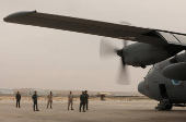 Members of Jordanian armed forces stand near a military plane loaded with aid parcels to be dropped over Gaza, in Zarqa