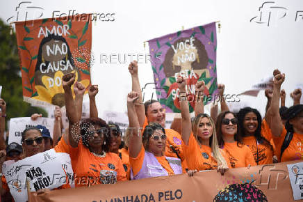 Demonstrators attend a walk, aimed to call for an end of violence against girls and women, in Copacabana beach in Rio de Janeiro