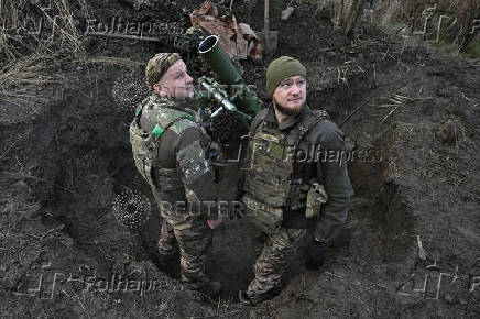 Policemen of the 'Khyzhak' Brigade prepare to fire a mortar towards Russian troops at their position in a front line near the town of Toretsk