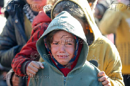 Palestinians gather to receive food cooked by a charity kitchen, in Khan Younis