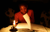 FILE PHOTO: Kea Modiba studies with candle light during one of the frequent power outages