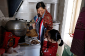 Yang prepares a meal at her apartment in a town bordering Beijing