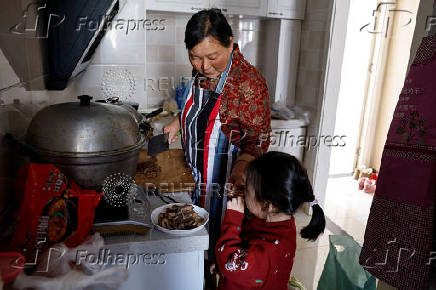 Yang prepares a meal at her apartment in a town bordering Beijing