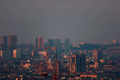 The Notre-Dame de Paris Cathedral is surrounded by a small-particle haze which hangs above the skyline in Paris