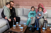 Akram Shalbout, a Syrian living in Jordan, sits with his family, in Irbid