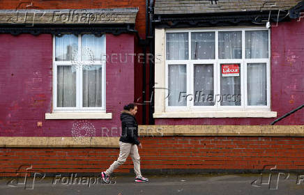 People walk past a 'Vote Labour' sign ahead of the May 2nd Blackpool South by-election