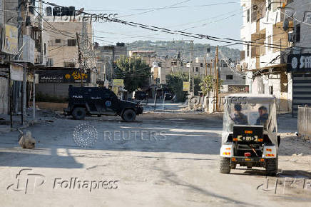 Palestinian security forces patrol amid clashes with militants at the camp in Jenin