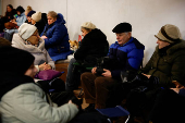 People take shelter inside a metro station during a Russian military strike, in Kyiv