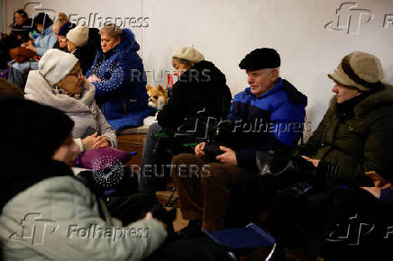 People take shelter inside a metro station during a Russian military strike, in Kyiv