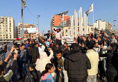 People gesture as a man holds the Syrian opposition flag, after Syrian rebels announced that they have ousted President Bashar al-Assad, in Tripoli, northern Lebanon